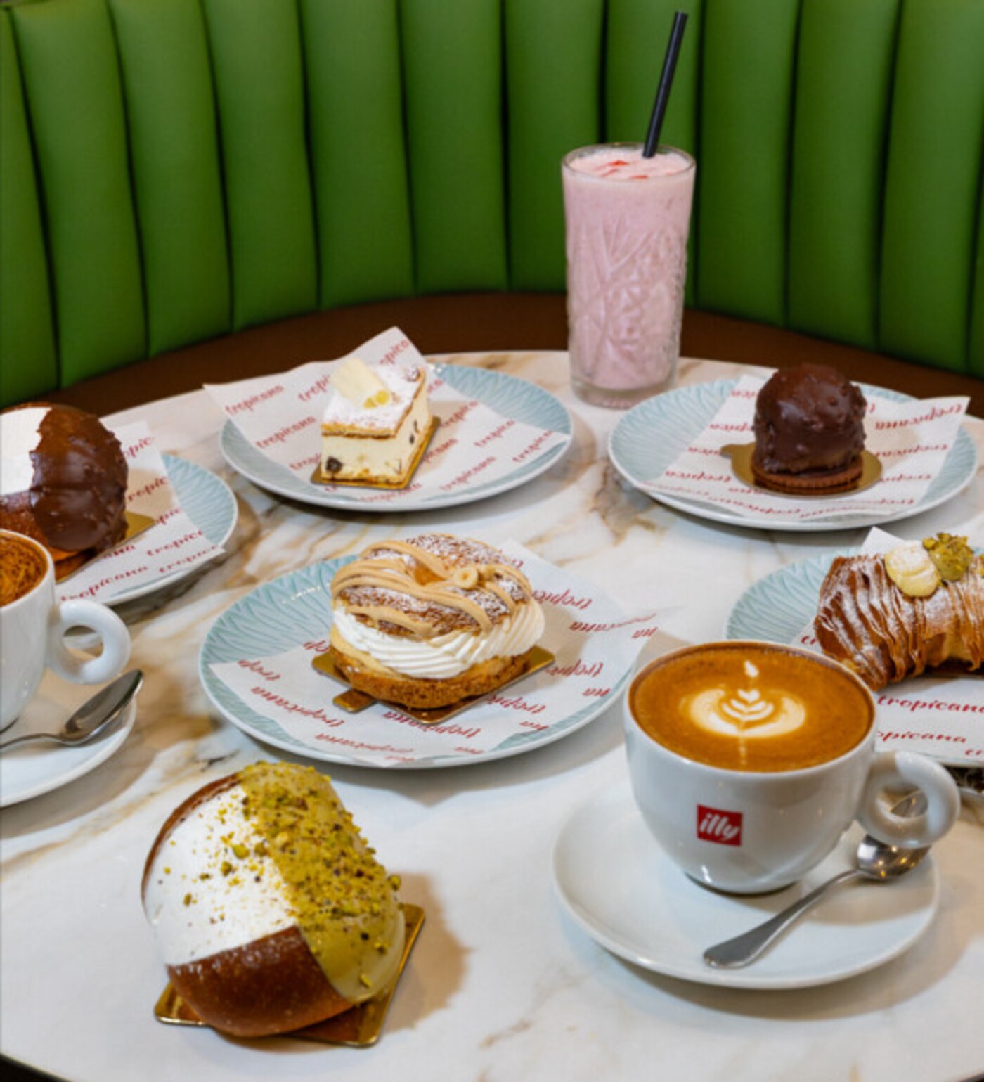 The counter sweets case at Tropicana with a cappuccino and milkshake